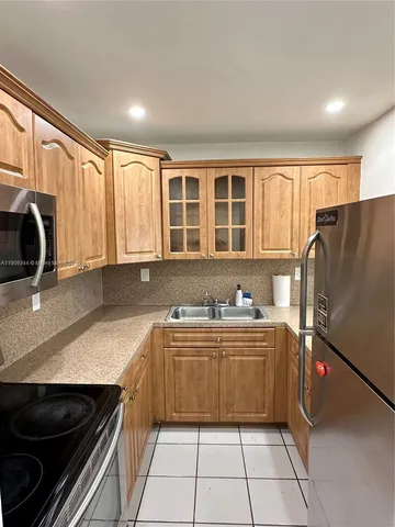 a kitchen with stainless steel appliances a stove a sink and a refrigerator