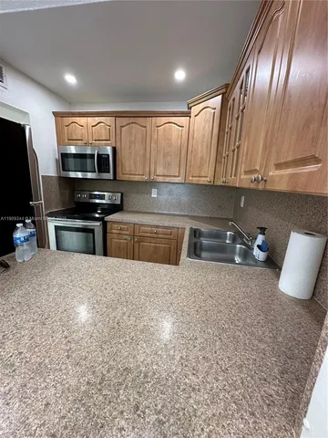 a kitchen with stainless steel appliances granite countertop a sink stove and cabinets