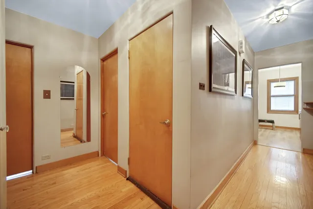 a view of a hallway with wooden floor and cabinets