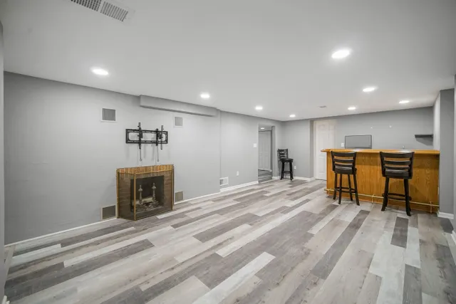 a room with wooden floor and pool table