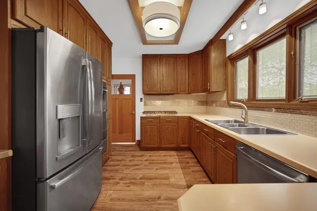 a kitchen with stainless steel appliances granite countertop a refrigerator a sink dishwasher and a stove