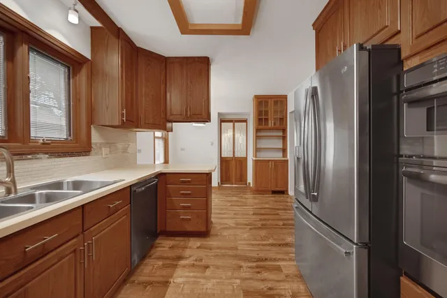 a kitchen with stainless steel appliances granite countertop a refrigerator and a sink
