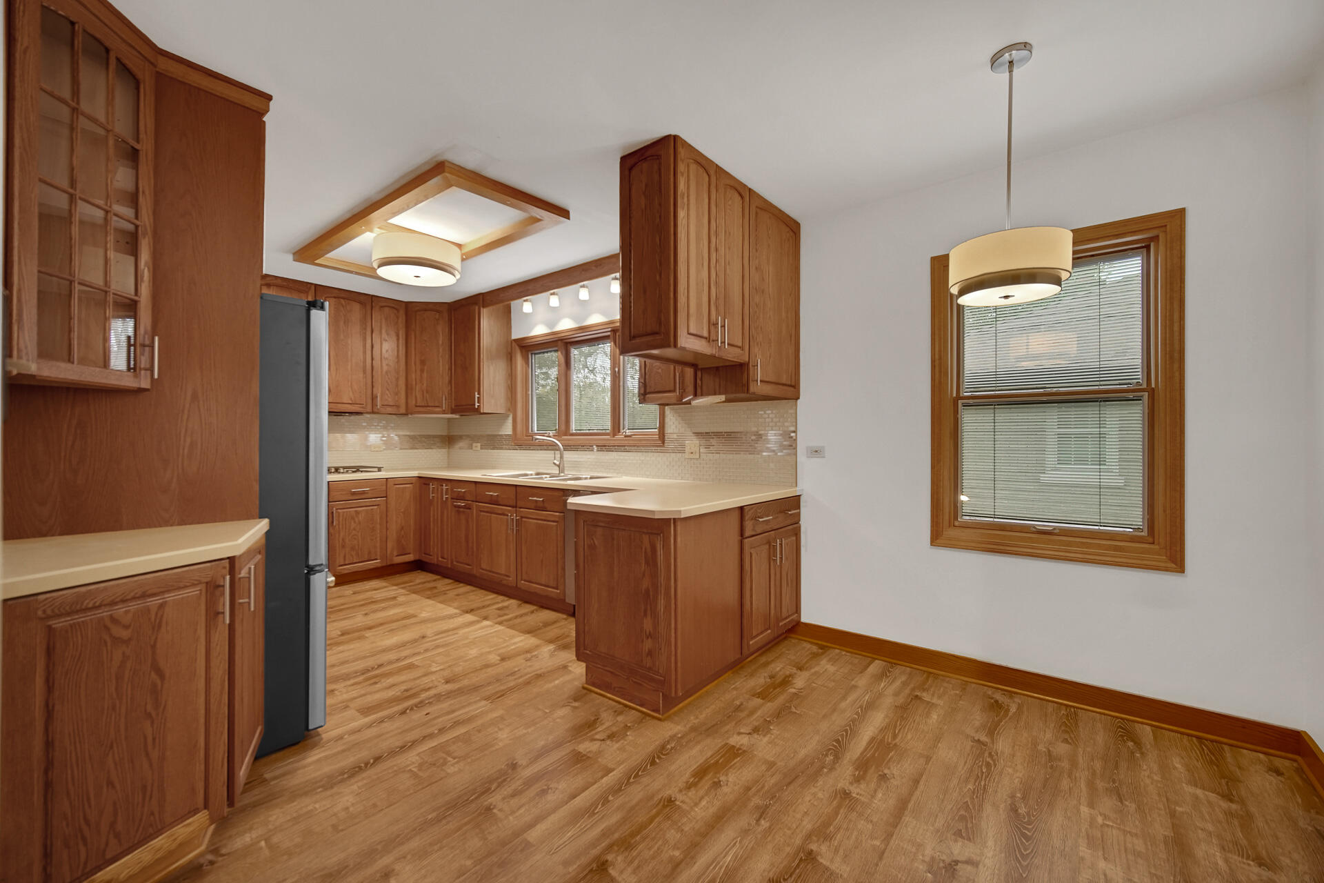 8342 Howard Avenue Munster, IN 46321 - Photo 9 of 31 a kitchen with kitchen island granite countertop wooden cabinets a sink a stove and a wooden floor