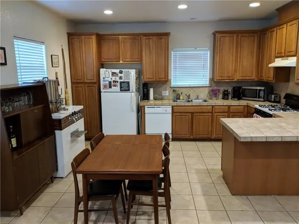 a kitchen with a refrigerator a stove a sink dishwasher and wooden cabinets