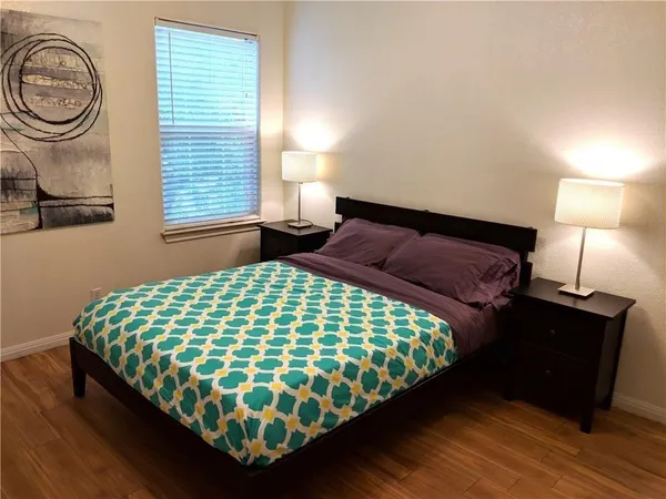 a bedroom with a bed and a lamp next to a window
