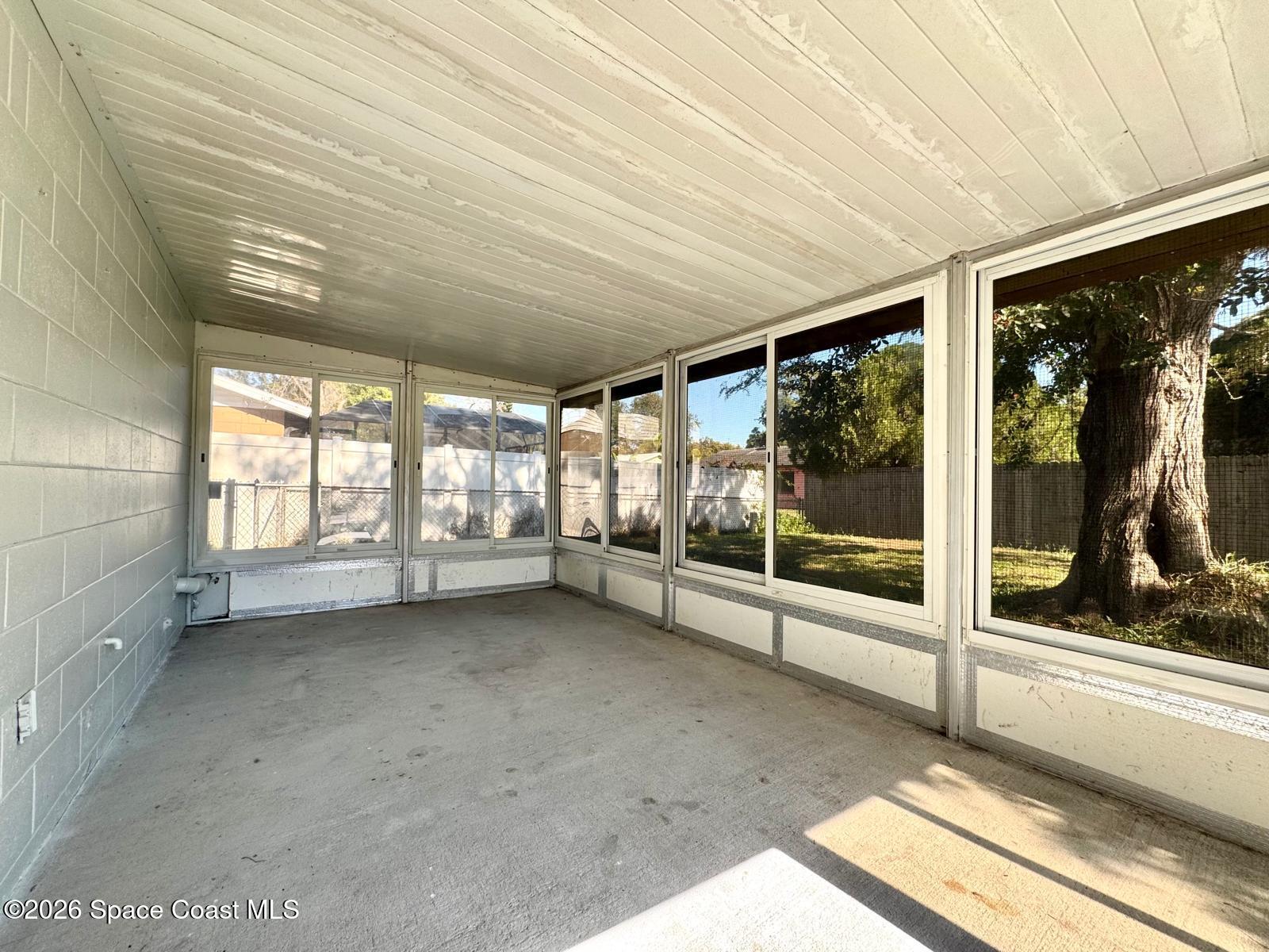 518 Sylvia Road Melbourne, FL 32904 - Photo 11 of 18 a view of an empty room with wooden floor and a window