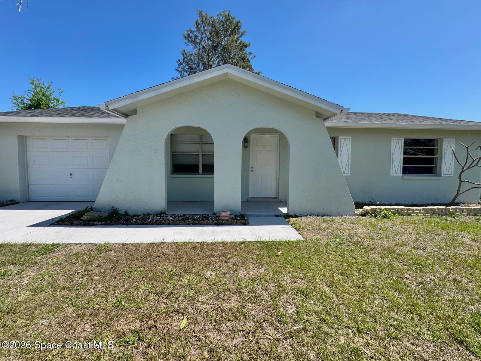 518 Sylvia Road Melbourne, FL 32904 - Photo 17 of 18 a house with trees in front of it