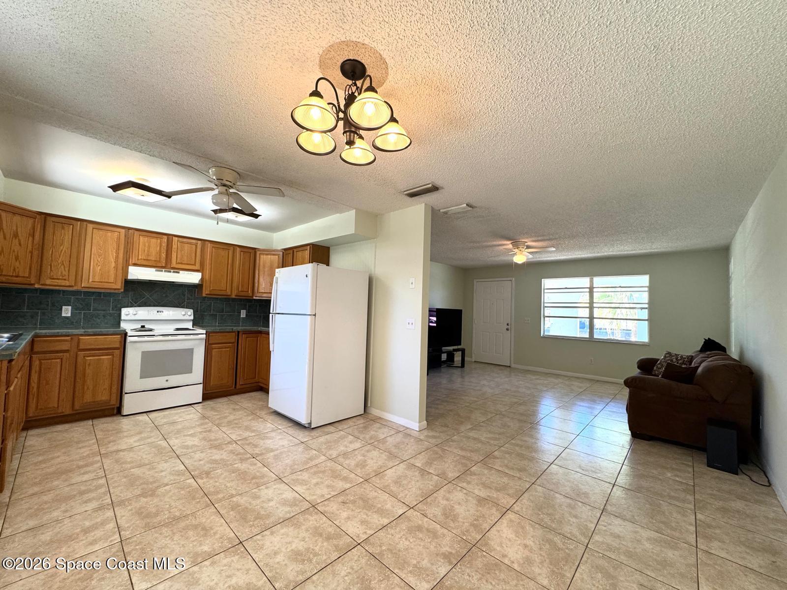 518 Sylvia Road Melbourne, FL 32904 - Photo 4 of 18 a kitchen with stainless steel appliances kitchen island granite countertop a stove and a sink with cabinets