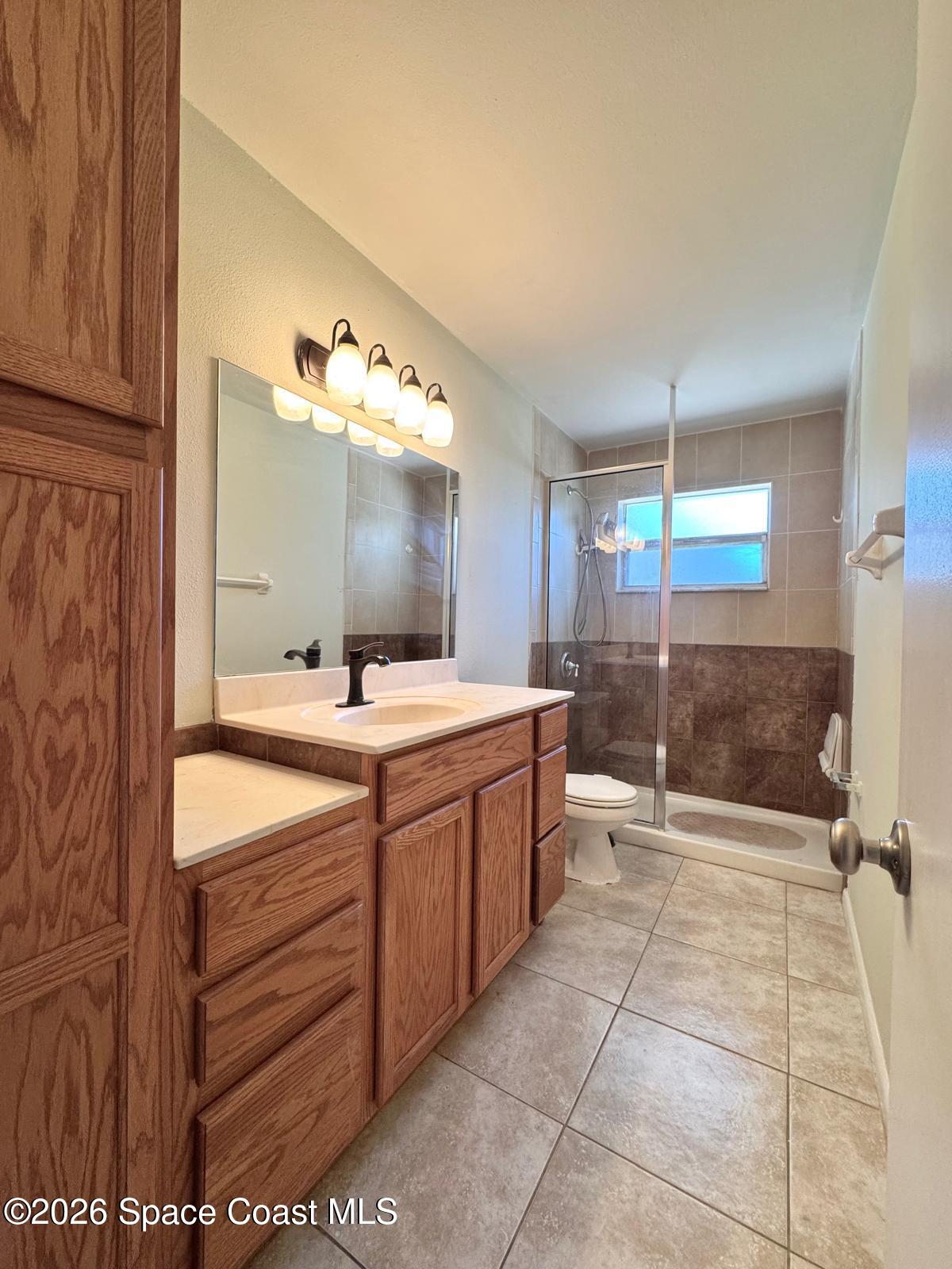 518 Sylvia Road Melbourne, FL 32904 - Photo 6 of 18 a bathroom with a double vanity sink toilet and shower