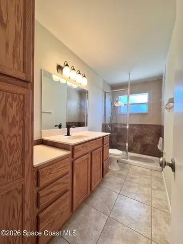 a bathroom with a double vanity sink toilet and shower