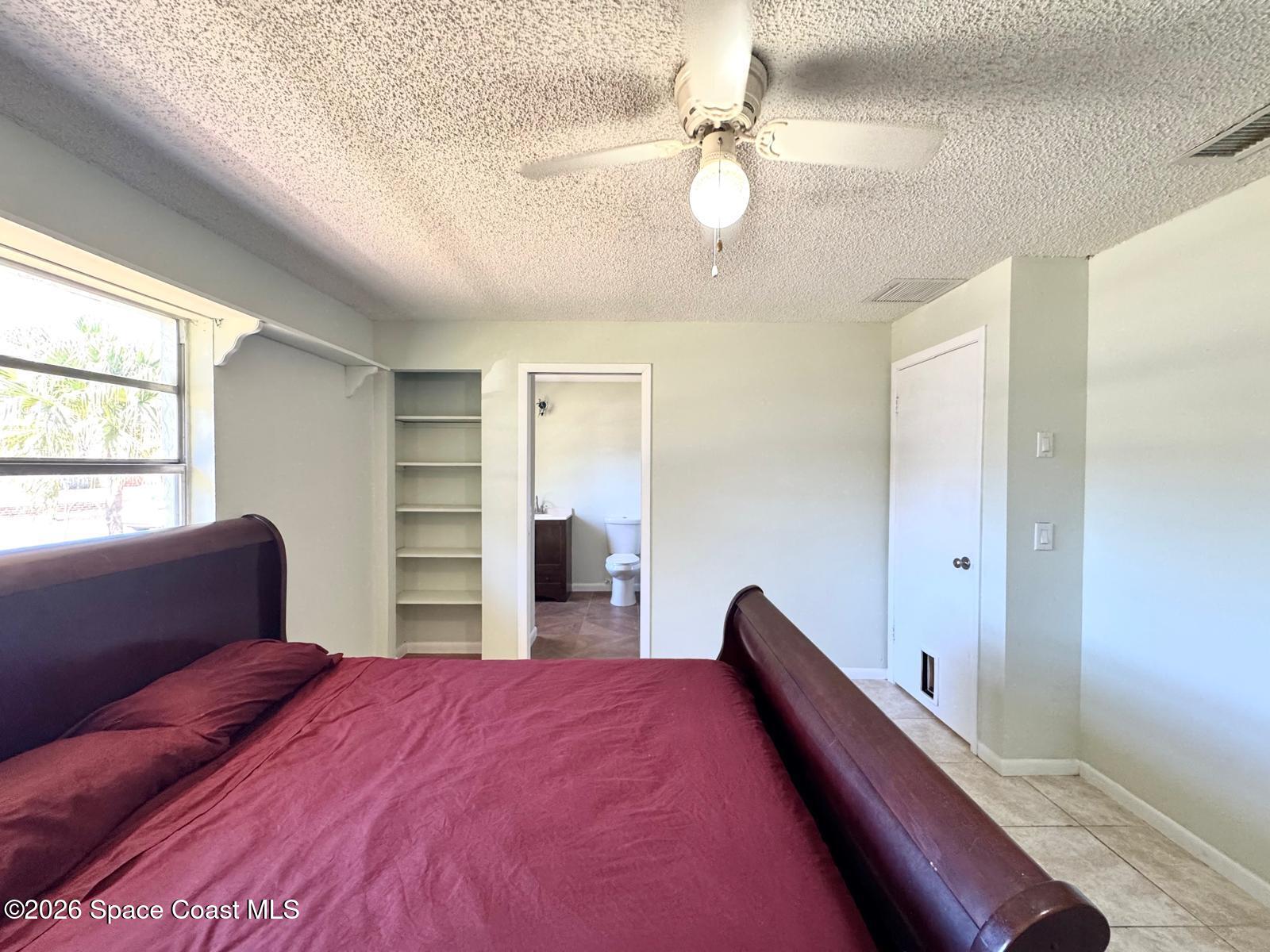 518 Sylvia Road Melbourne, FL 32904 - Photo 8 of 18 a bedroom with a bed and a chandelier