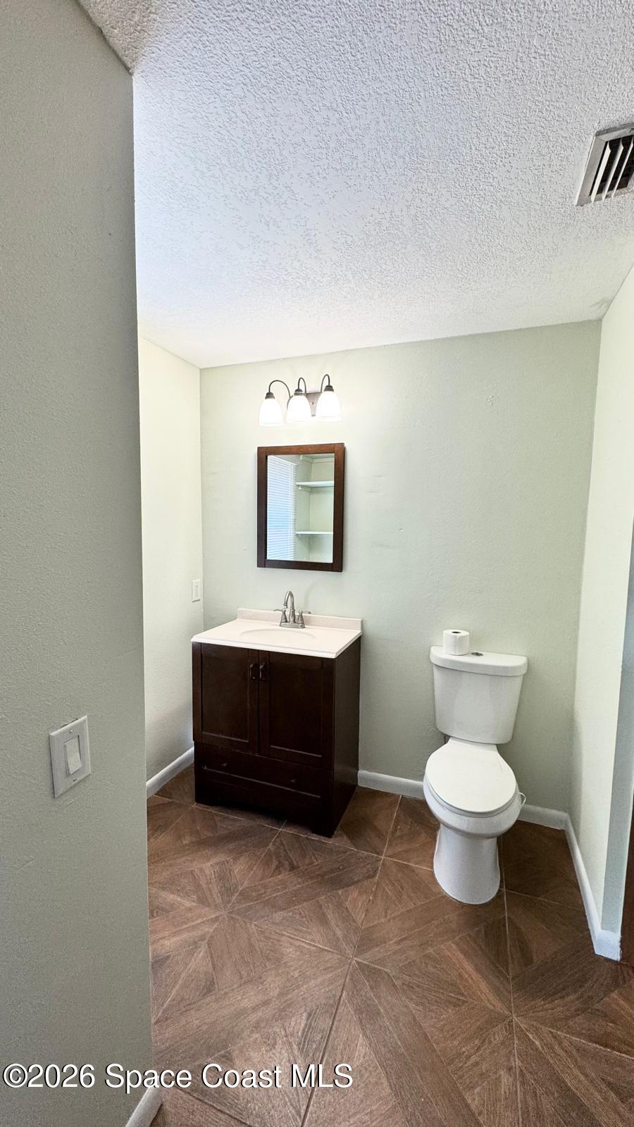 518 Sylvia Road Melbourne, FL 32904 - Photo 10 of 18 a bathroom with a toilet sink and mirror
