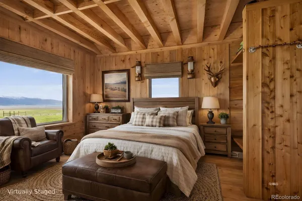 a bedroom with a bed a couch and large windows