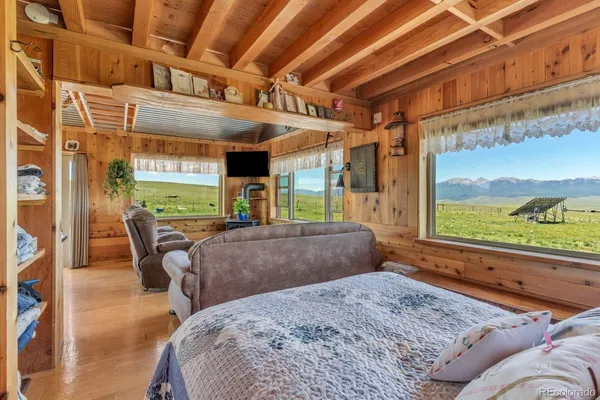 a bedroom with furniture and a large window