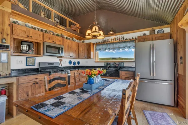 a kitchen with stainless steel appliances granite countertop a refrigerator a stove and a sink with granite countertops