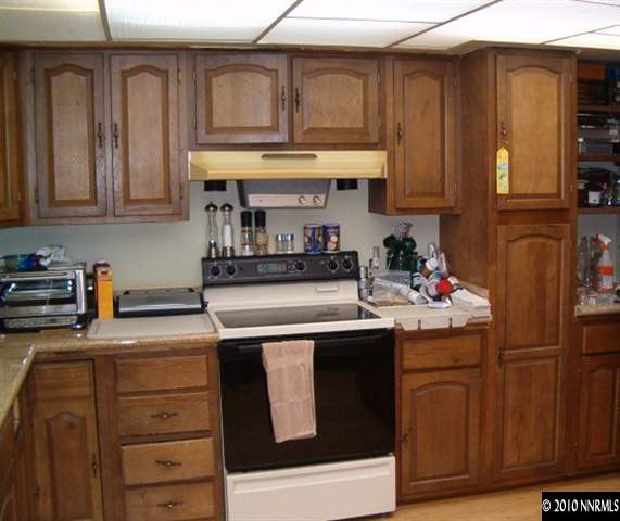 1290 Manhattan Street Reno, NV 89512 - Photo 3 of 9 a kitchen with stainless steel appliances granite countertop a refrigerator and a stove top oven