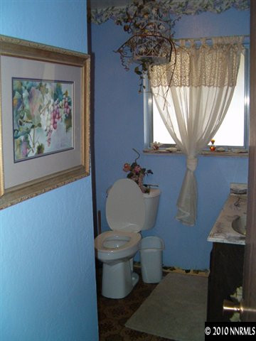 1290 Manhattan Street Reno, NV 89512 - Photo 6 of 9 a bathroom with a toilet and a painting on the wall