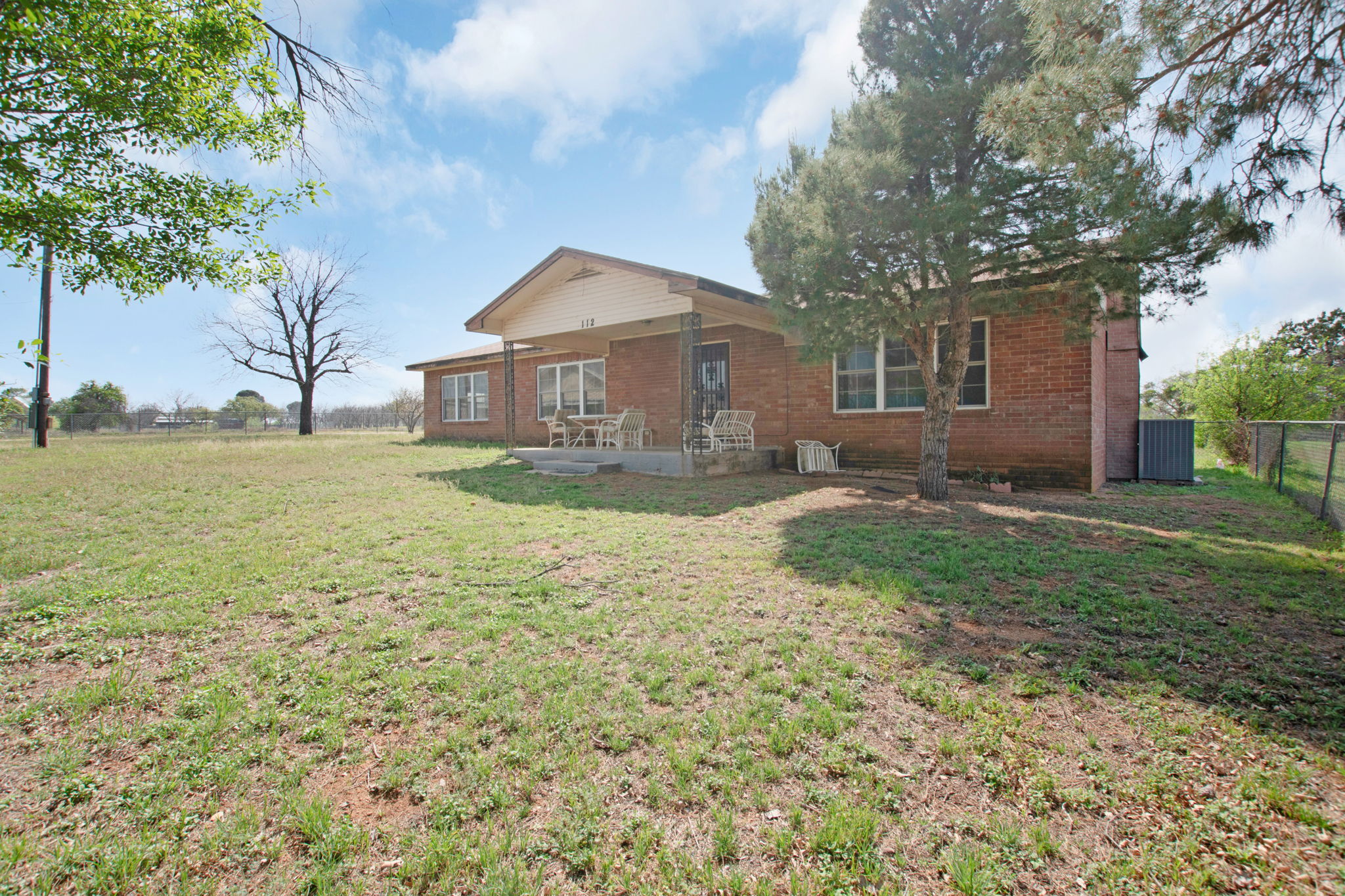 112 Frazier Tow, TX 78672 - Photo 2 of 30 Front of house with fence, brick siding, and a yard