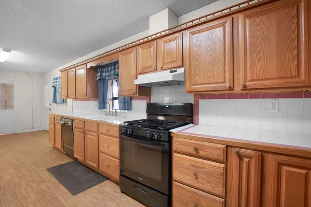 a kitchen with stainless steel appliances granite countertop a stove a sink and cabinets