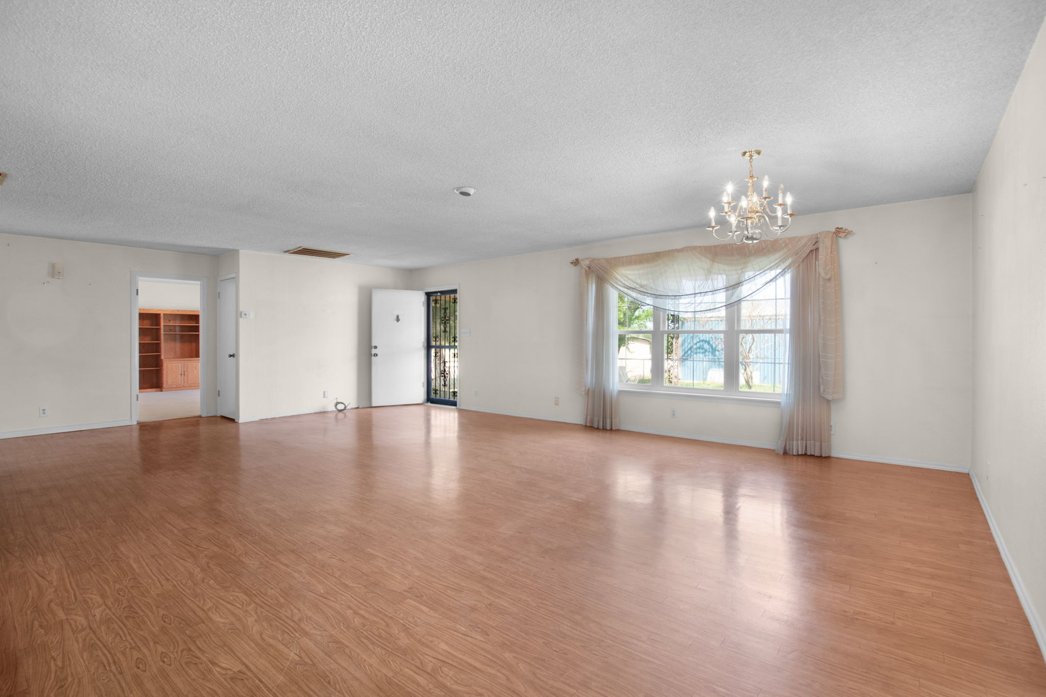 112 Frazier Tow, TX 78672 - Photo 8 of 30 Spare room with a textured ceiling, visible vents, light wood-style flooring, a chandelier, and baseboards