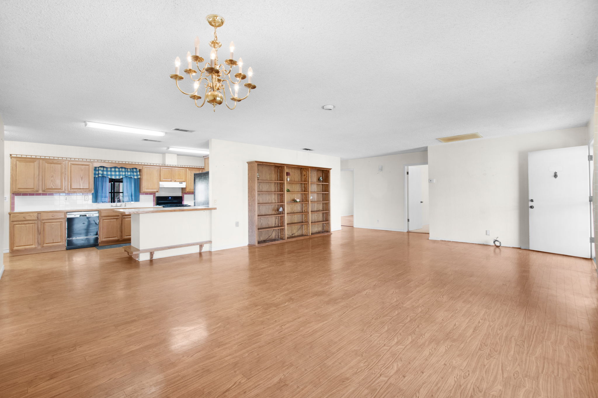 112 Frazier Tow, TX 78672 - Photo 9 of 30 Unfurnished living room with light wood-style flooring, a textured ceiling, a chandelier, and visible vents