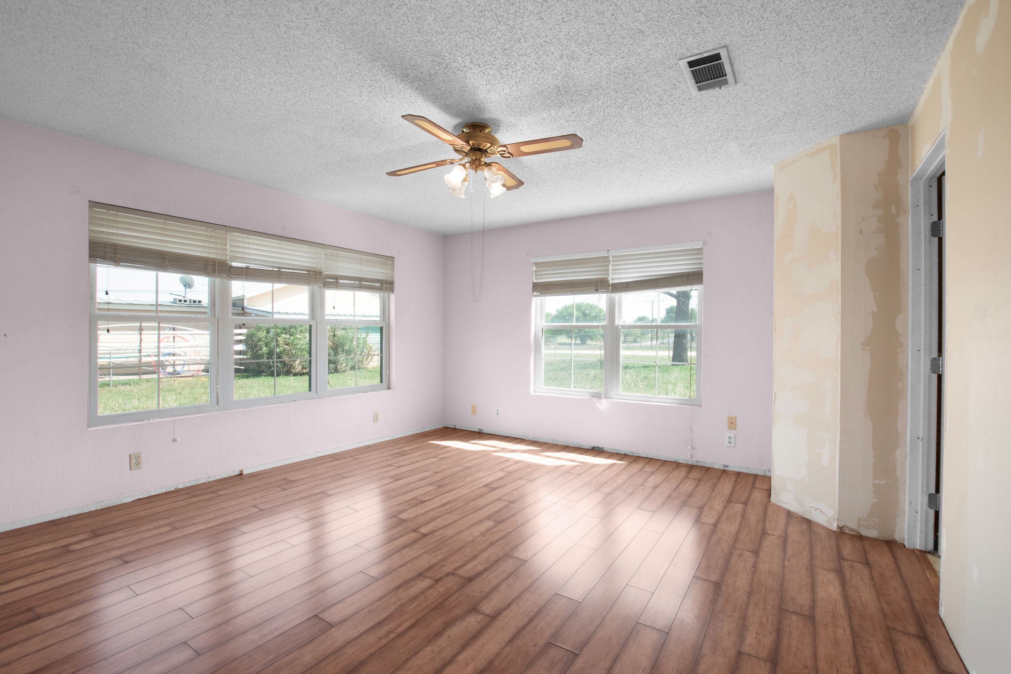112 Frazier Tow, TX 78672 - Photo 10 of 30 Spare room with visible vents, ceiling fan, wood finished floors, and a healthy amount of sunlight