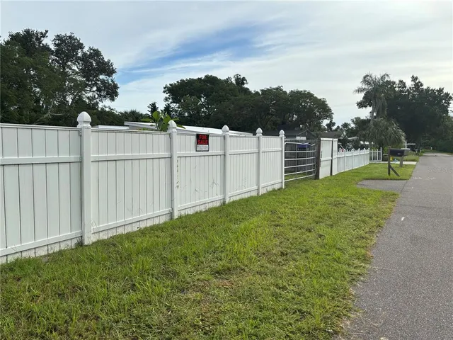 a view of a backyard with wooden fence