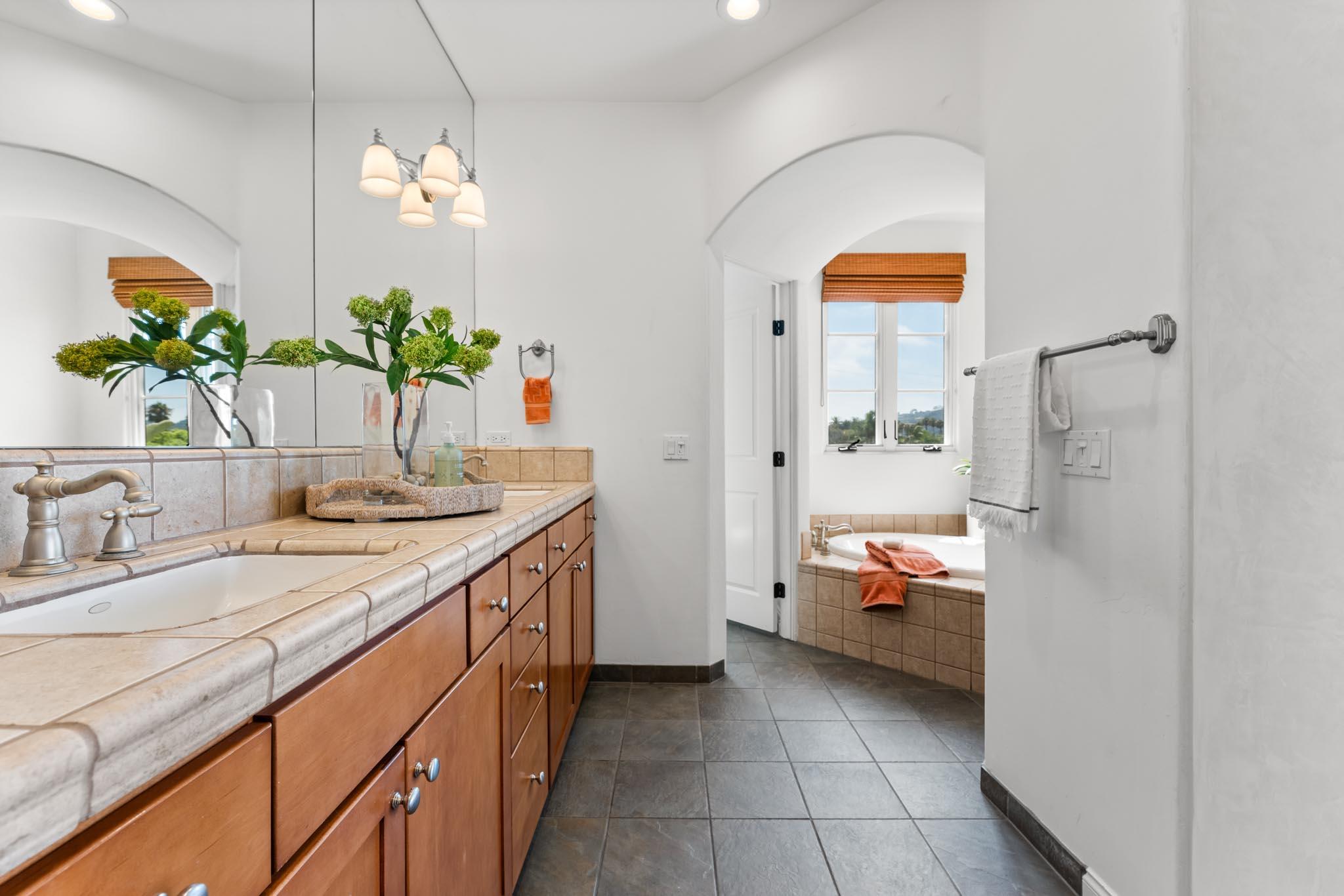 212 Santa Barbara Street, Unit B Santa Barbara, CA 93101 - Photo 15 of 28 a bathroom with a granite countertop sink a toilet and a mirror