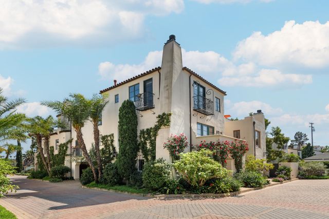 a front view of a house with a yard and potted plants
