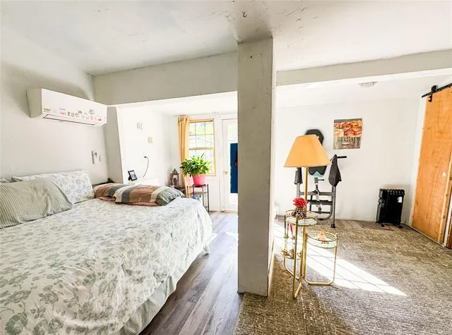 a bedroom with a bed and a potted plant on the dresser