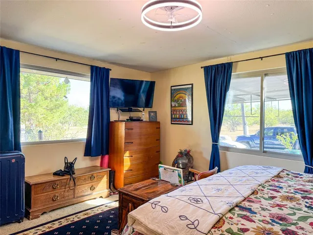 a bedroom with a bed and a dresser next to a window