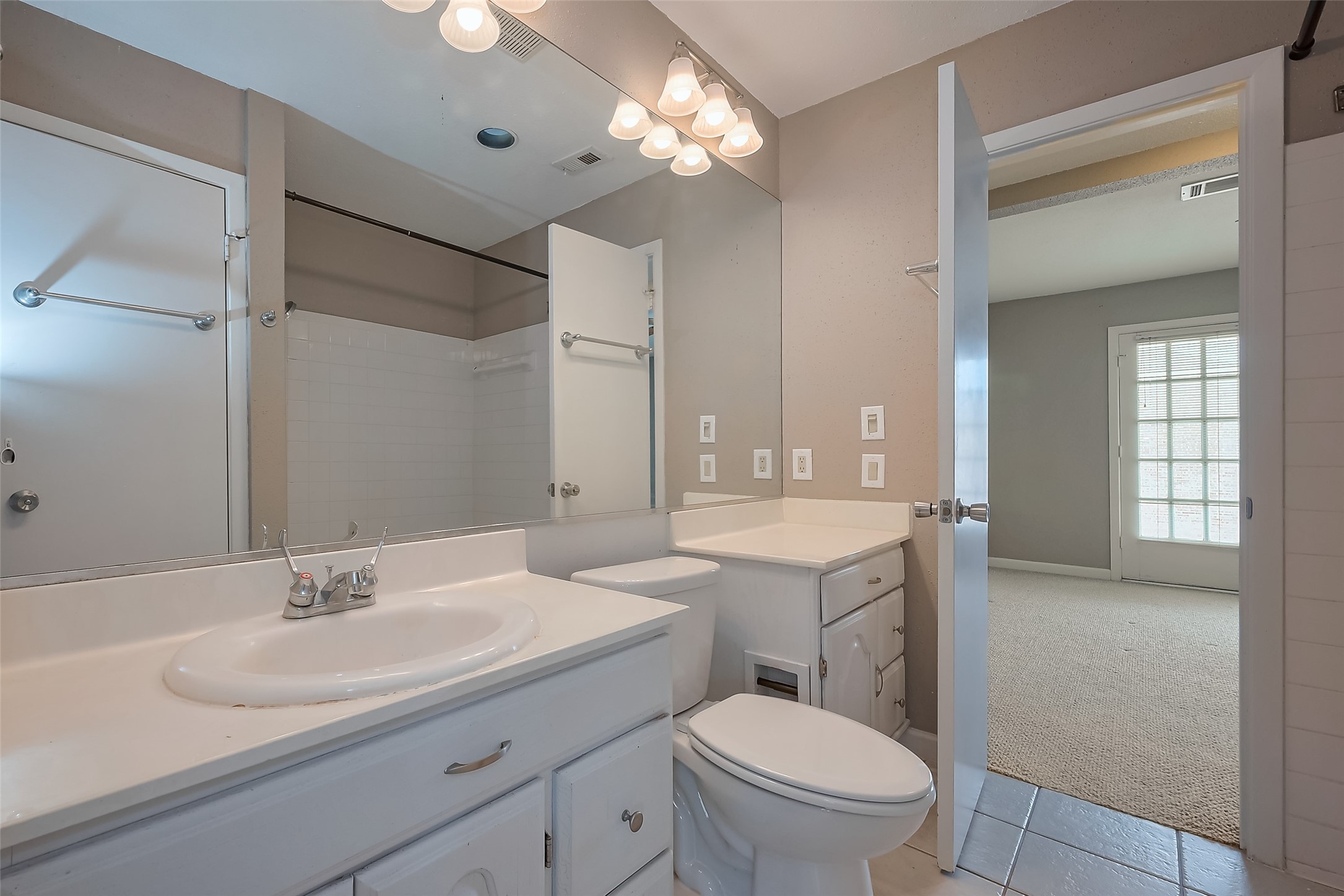 6111 Beverly Hill Street, Unit 29 Houston, TX 77057 - Photo 13 of 22 a bathroom with a toilet a sink a mirror a vanity and window