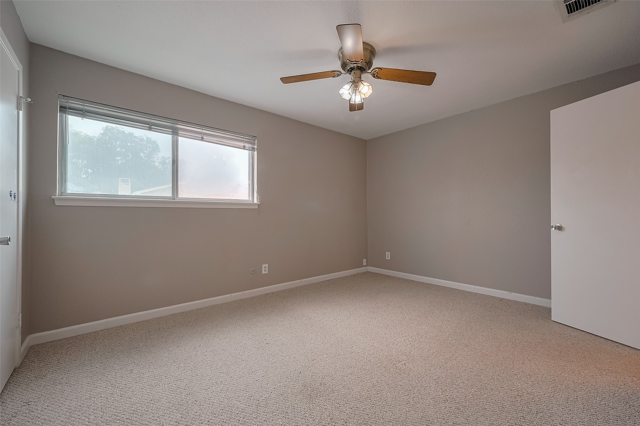 6111 Beverly Hill Street, Unit 29 Houston, TX 77057 - Photo 19 of 22 an empty room with a chandelier fan and windows