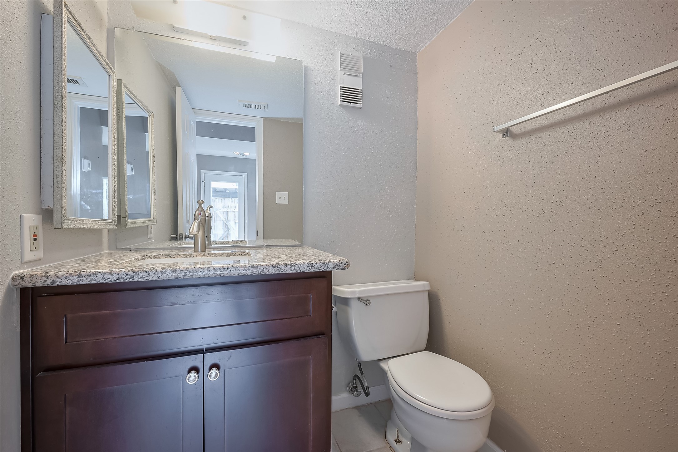 6111 Beverly Hill Street, Unit 29 Houston, TX 77057 - Photo 10 of 22 a bathroom with a granite countertop toilet sink and mirror