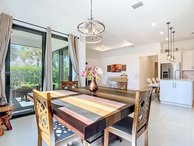 a dining room with furniture large windows and a chandelier