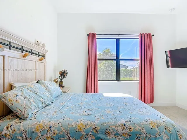 a bedroom with a large bed and a window