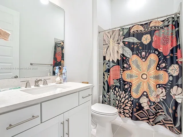 a bathroom with a sink and mirror with toilet
