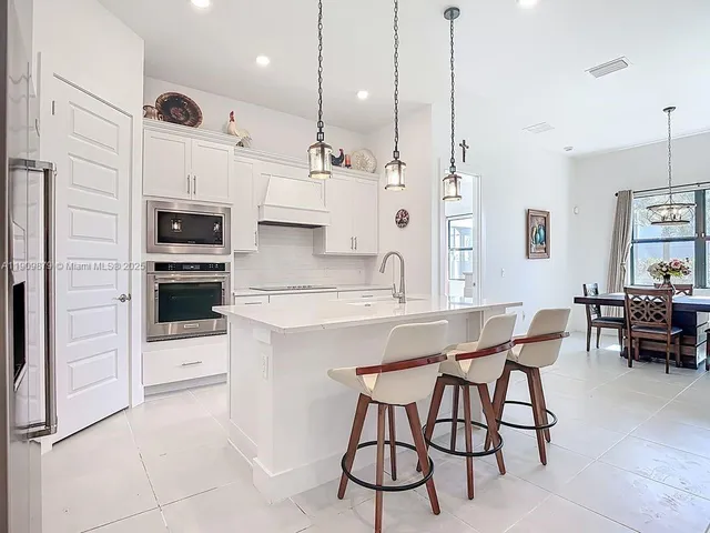 a kitchen with stainless steel appliances kitchen island granite countertop a stove a sink and a refrigerator