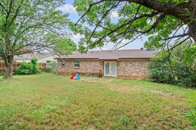 a view of a house with a backyard and a tree
