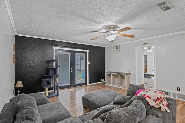 a living room with furniture and a ceiling fan