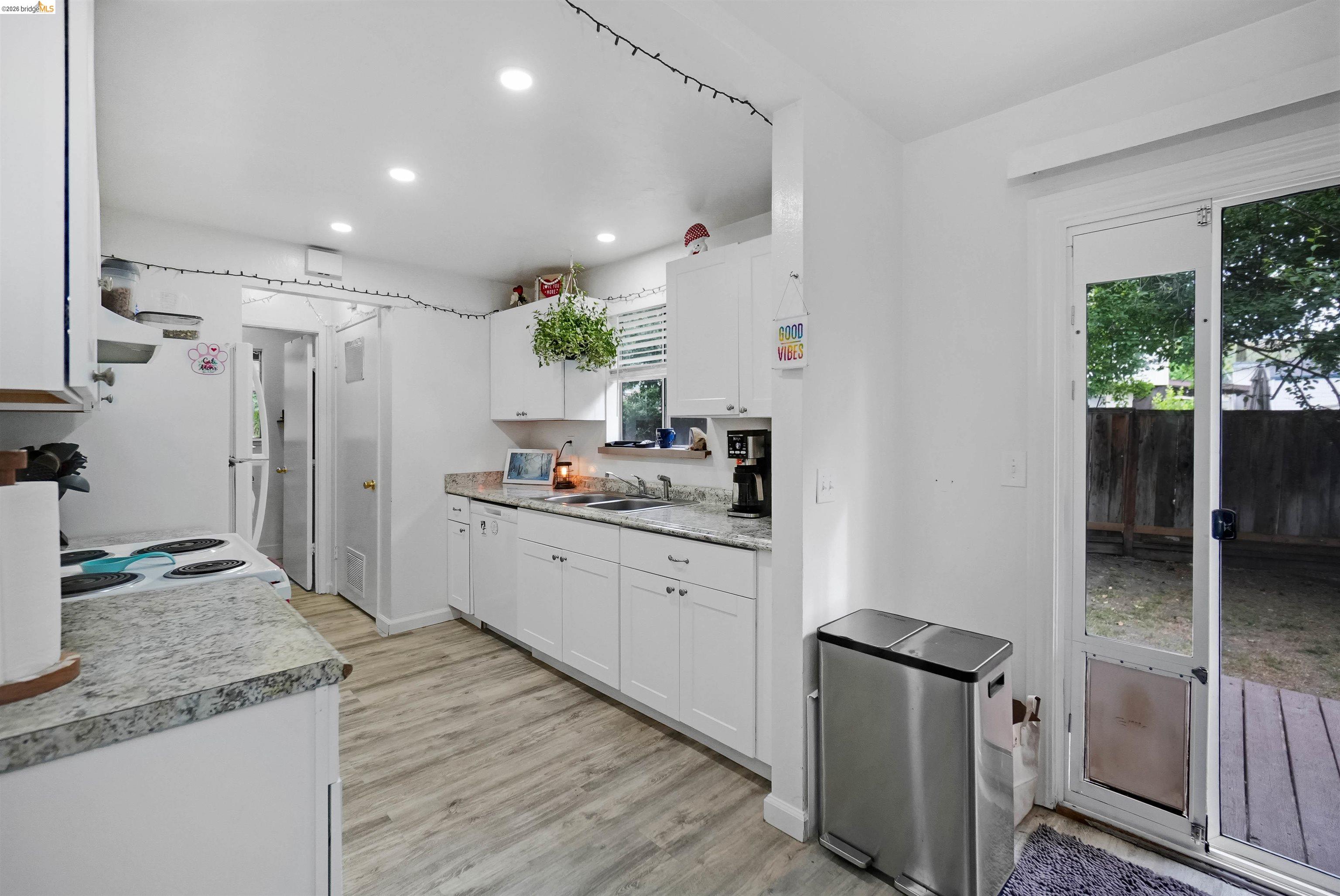 1066 San Miguel Road Concord, CA 94518 - Photo 17 of 59 Kitchen with white cabinetry, light countertops, recessed lighting, white appliances, and light wood-type flooring