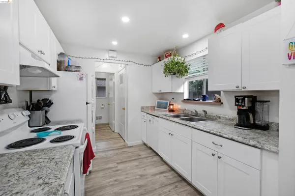 a kitchen with granite countertop a sink a stove and cabinets