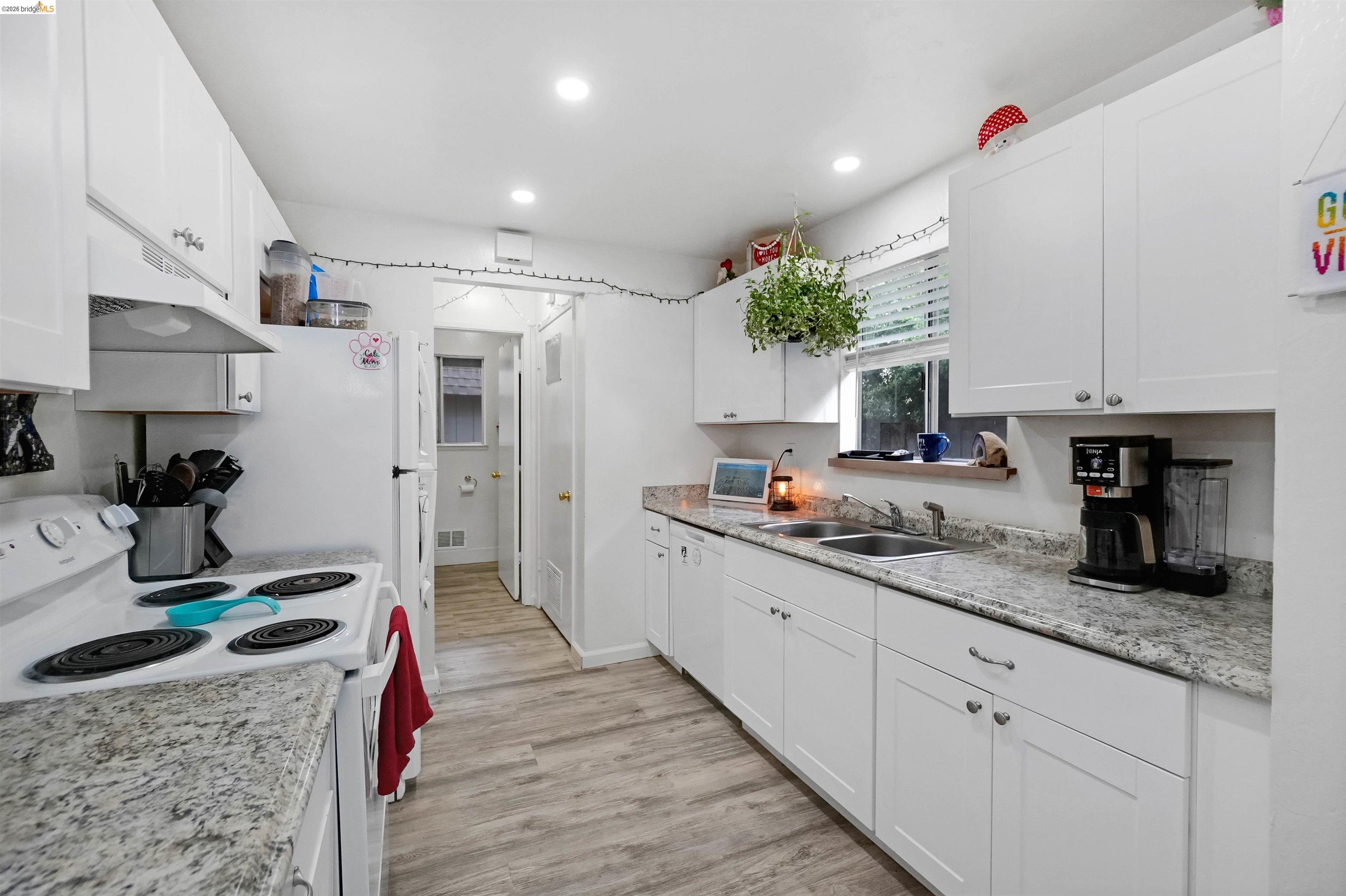 1066 San Miguel Road Concord, CA 94518 - Photo 18 of 59 Kitchen featuring white appliances, white cabinetry, light wood finished floors, and recessed lighting