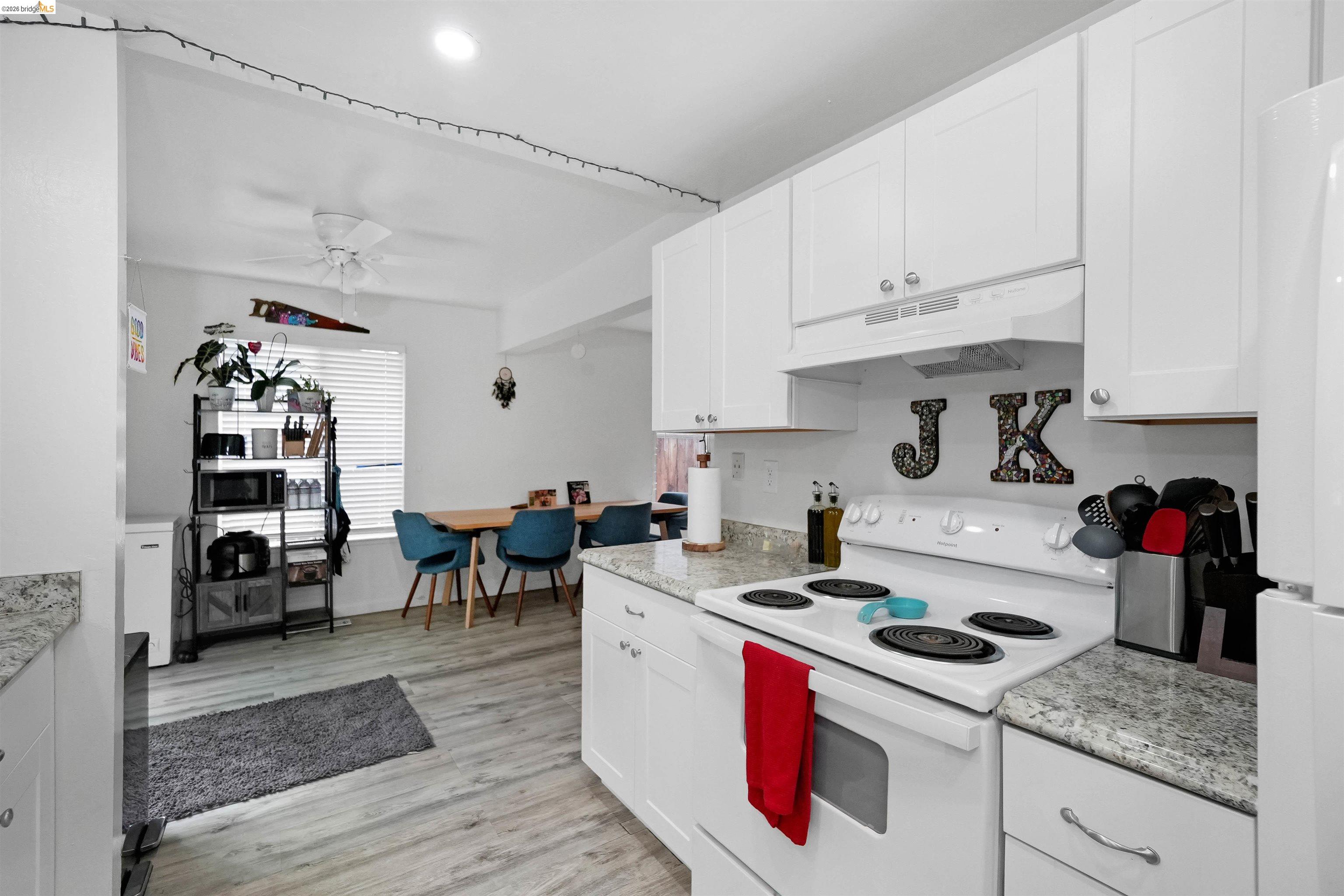 1066 San Miguel Road Concord, CA 94518 - Photo 20 of 59 Kitchen with white appliances, white cabinetry, light countertops, and light wood finished floors