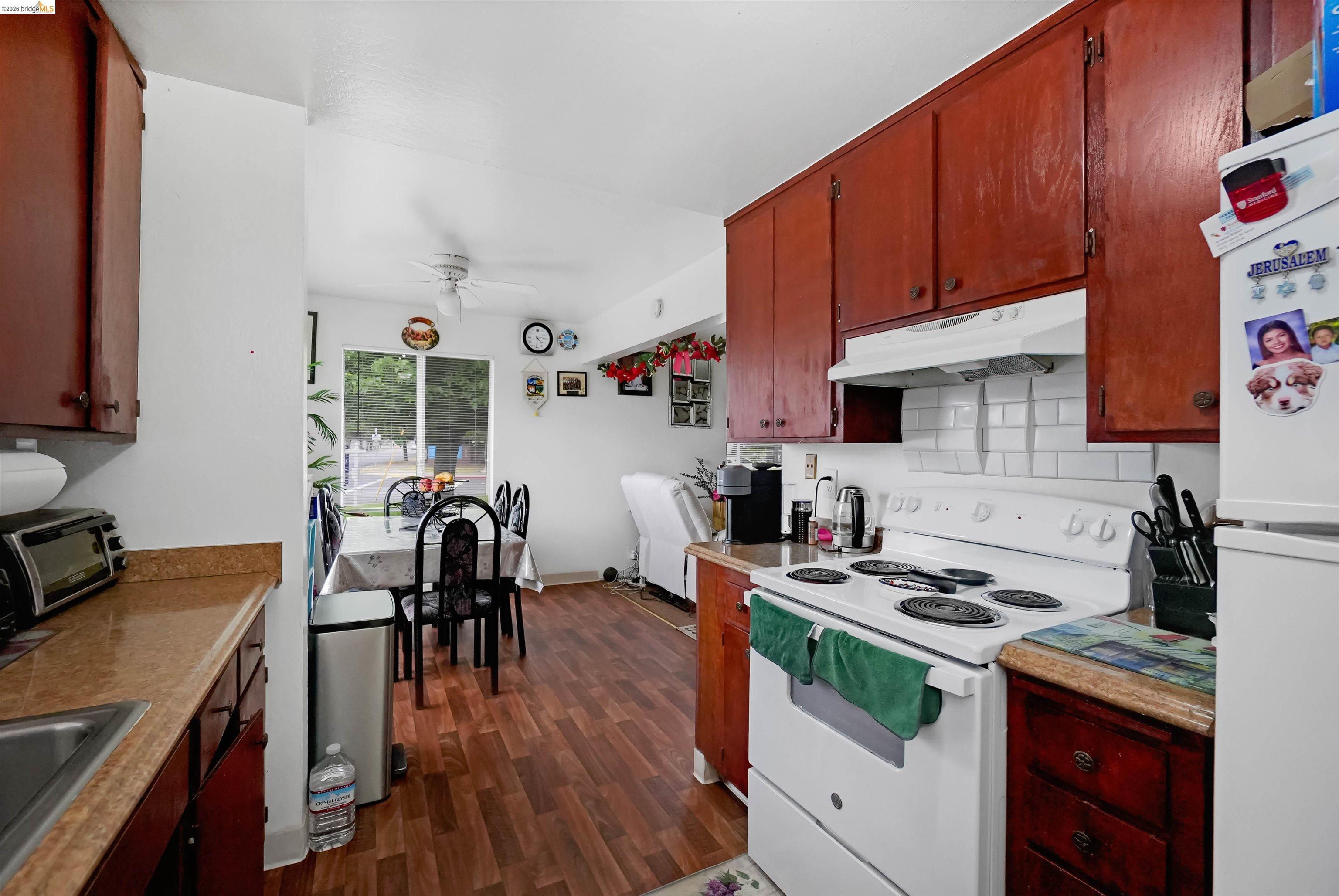 1066 San Miguel Road Concord, CA 94518 - Photo 45 of 59 Kitchen with white appliances, backsplash, light countertops, dark wood-type flooring, and a ceiling fan