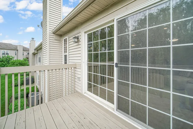 a view of a balcony with a floor to ceiling window wooden floor and fence