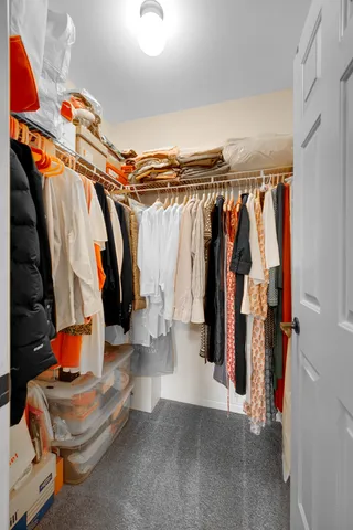 a view of walk in closet with clothes and shoes