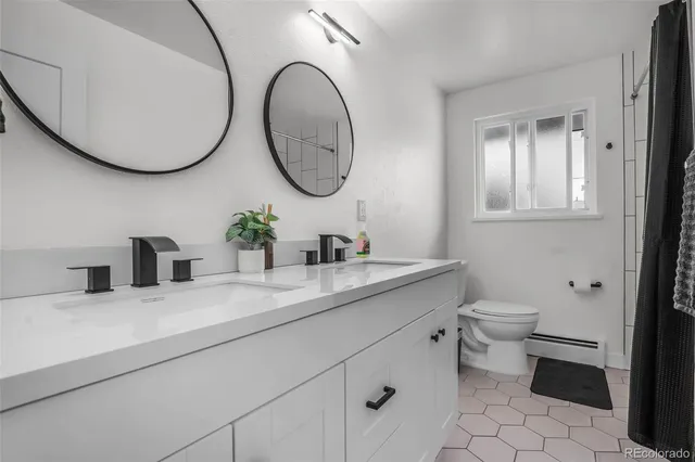 a bathroom with a granite countertop toilet sink and mirror
