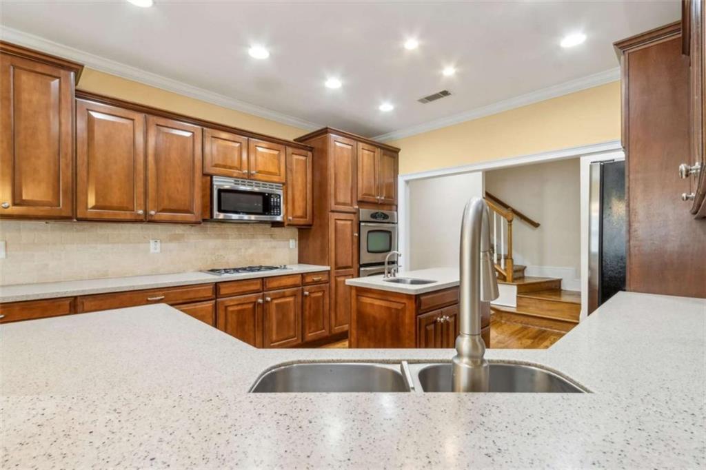 94 Appalachee Church Road Auburn, GA 30011 - Photo 26 of 66 a kitchen with stainless steel appliances granite countertop a sink and a stove top oven with wooden floors