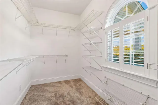 an empty room with windows and ceiling fan